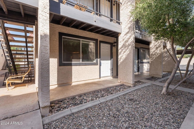 property entrance with a balcony and a patio area