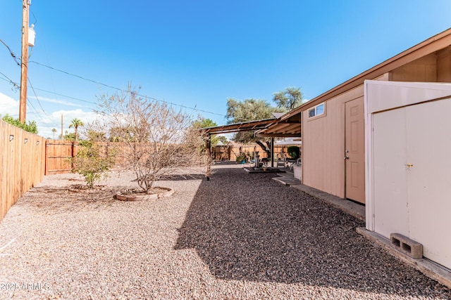 view of yard with a patio, an outdoor structure, and a fenced backyard