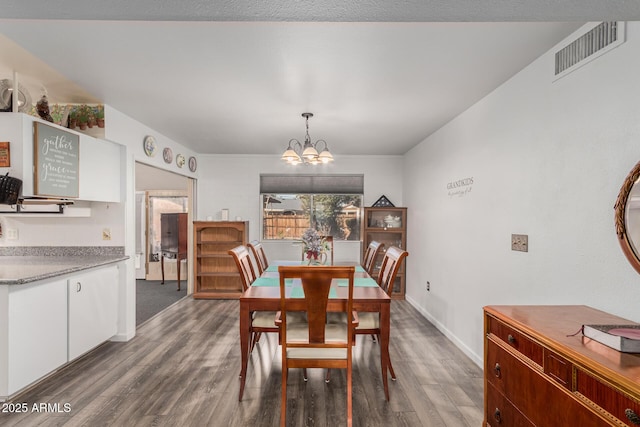 dining room with visible vents, baseboards, an inviting chandelier, and wood finished floors