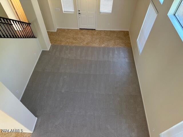 entryway with baseboards and carpet