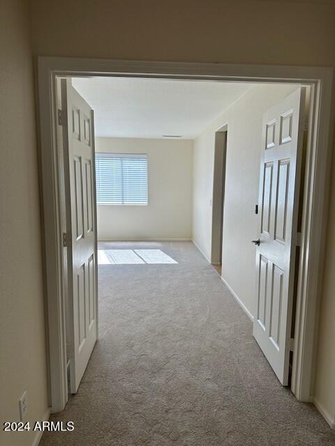 hallway with light colored carpet