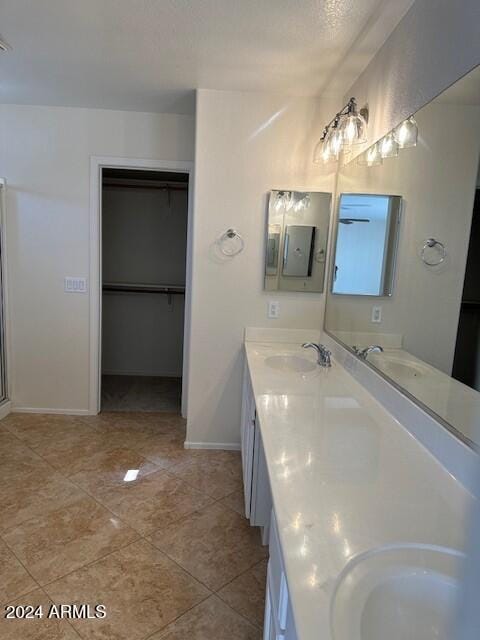 bathroom with double vanity, baseboards, and a sink