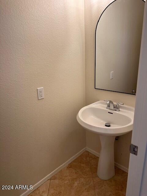 bathroom featuring tile patterned floors, baseboards, and a sink