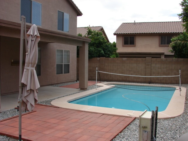 view of swimming pool featuring a patio, fence, and a fenced in pool