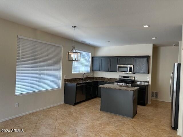 kitchen featuring visible vents, pendant lighting, a sink, a center island, and stainless steel appliances