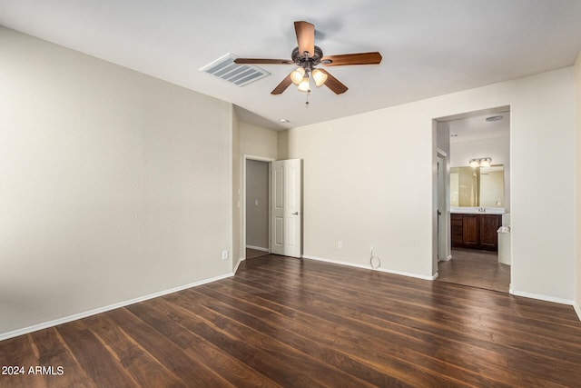 empty room with ceiling fan and dark hardwood / wood-style flooring