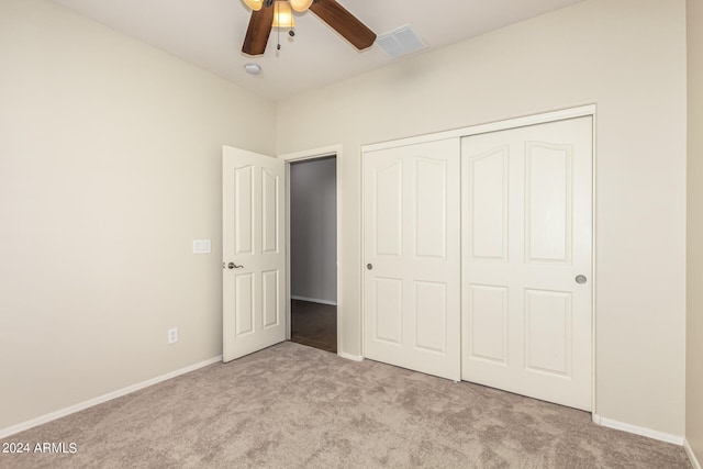 unfurnished bedroom with ceiling fan, a closet, and light carpet