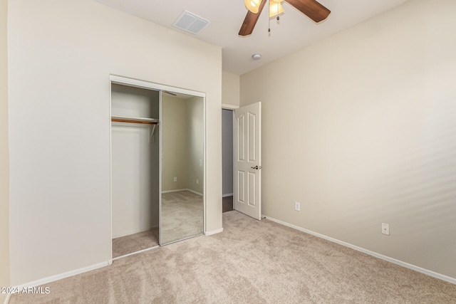 unfurnished bedroom with ceiling fan, light colored carpet, and a closet