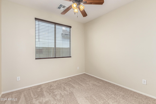 spare room featuring light carpet and ceiling fan