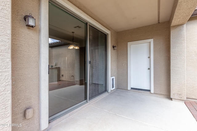 view of exterior entry featuring a patio area