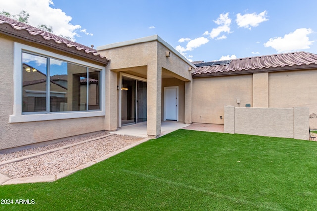 back of property with a lawn and a patio area