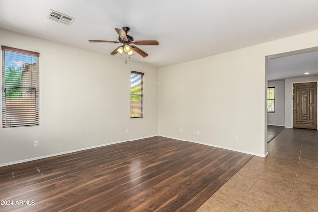 empty room with ceiling fan and dark hardwood / wood-style flooring