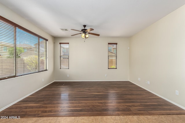 empty room with ceiling fan and dark wood-type flooring