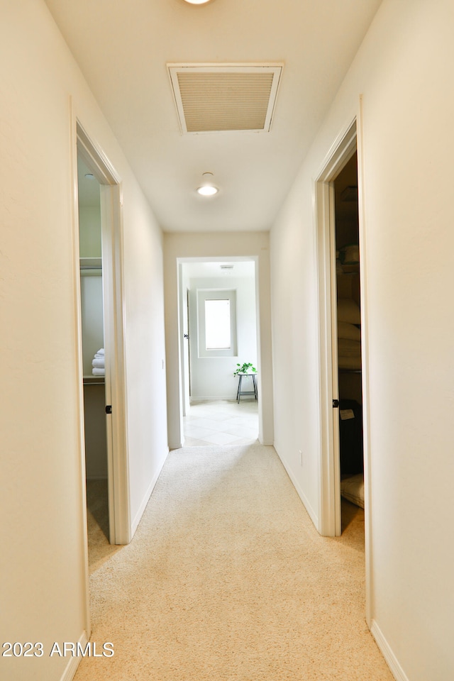 hallway featuring light colored carpet