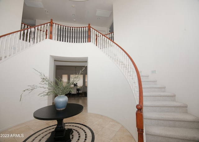 stairs featuring a high ceiling and tile patterned flooring