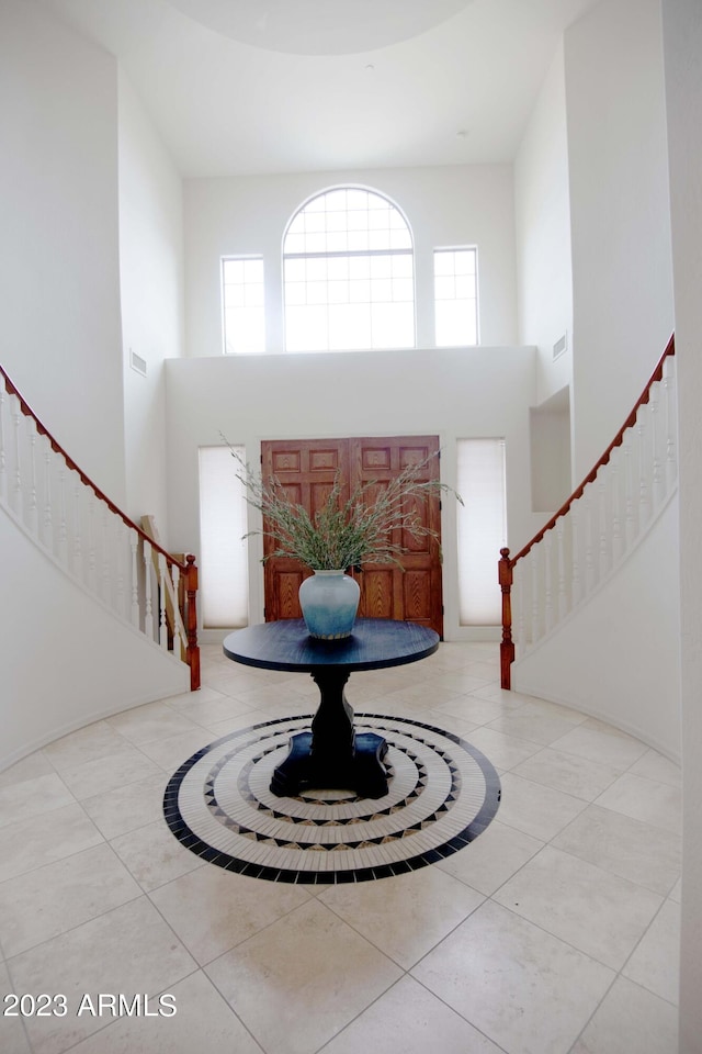 tiled entrance foyer featuring plenty of natural light and a towering ceiling