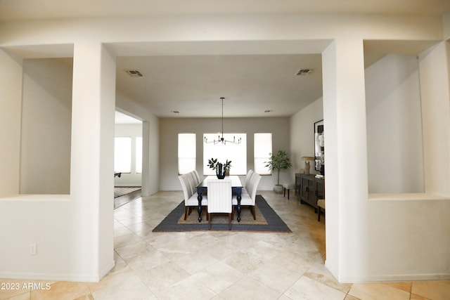 dining space featuring a notable chandelier and light tile patterned floors