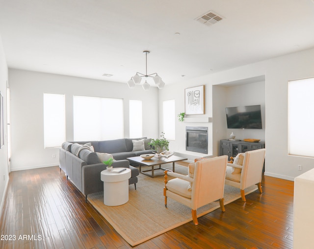 living room with dark hardwood / wood-style floors and a healthy amount of sunlight