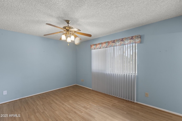 unfurnished room featuring ceiling fan, a textured ceiling, wood finished floors, and baseboards