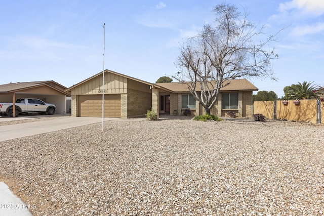 view of front of house featuring a garage, driveway, fence, and brick siding