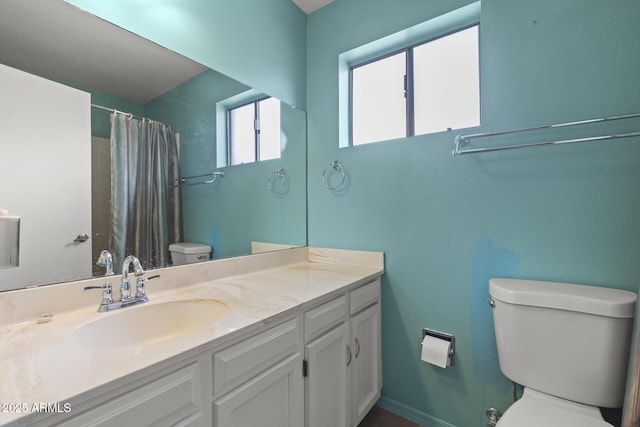 bathroom featuring a shower with curtain, baseboards, vanity, and toilet