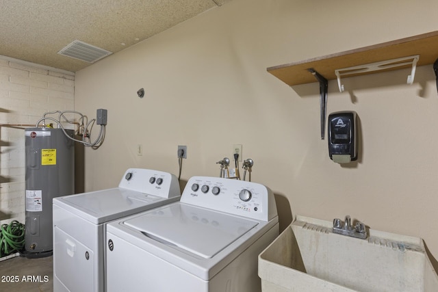 laundry area featuring laundry area, visible vents, washing machine and dryer, water heater, and a sink