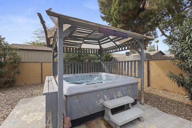 deck featuring a hot tub and a fenced backyard