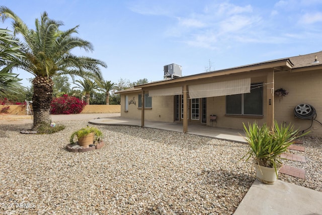 rear view of house with central AC and a patio