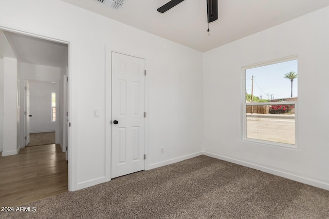 unfurnished bedroom featuring carpet flooring, ensuite bath, and ceiling fan