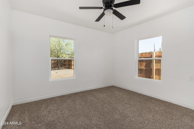 carpeted spare room featuring ceiling fan and a healthy amount of sunlight