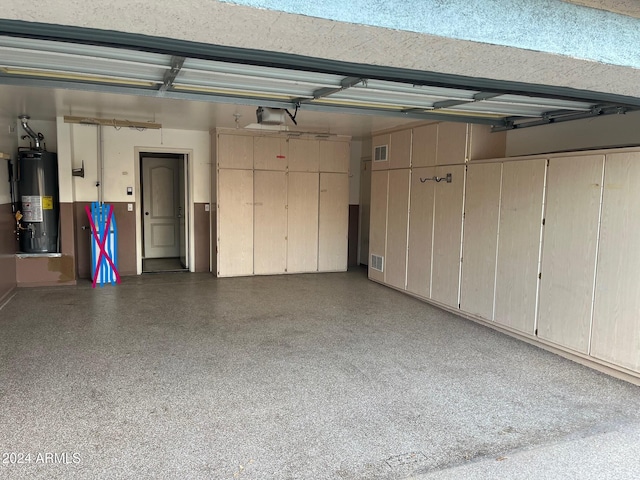 garage with gas water heater and a garage door opener