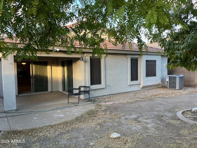 rear view of house featuring cooling unit and a patio