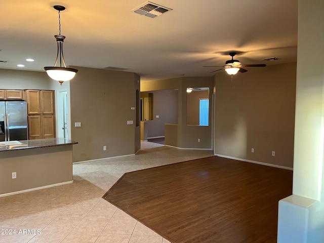 unfurnished living room featuring ceiling fan and light hardwood / wood-style flooring