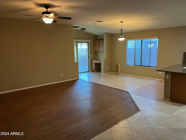 interior space featuring ceiling fan, light wood-type flooring, and vaulted ceiling