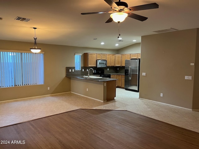 kitchen with kitchen peninsula, light hardwood / wood-style flooring, hanging light fixtures, and appliances with stainless steel finishes