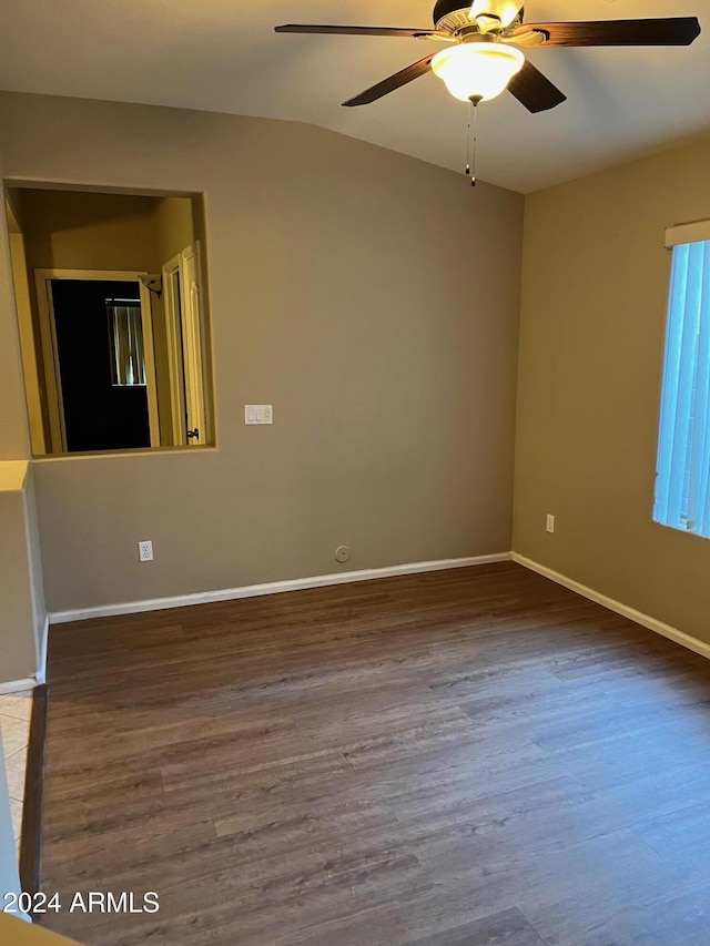 empty room featuring dark hardwood / wood-style floors, ceiling fan, and vaulted ceiling