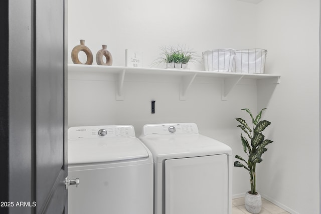 washroom featuring laundry area, light tile patterned floors, baseboards, and washer and clothes dryer