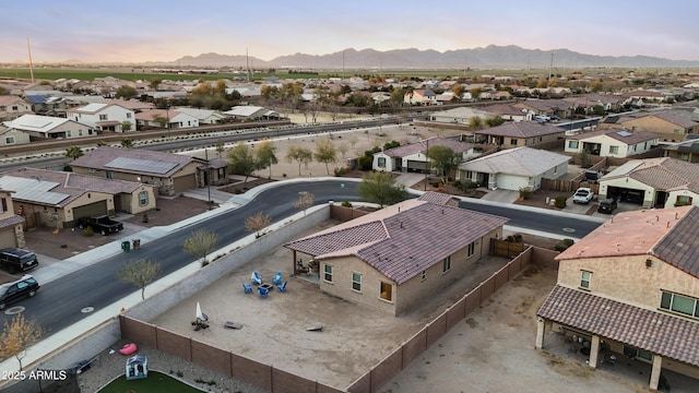 aerial view at dusk featuring a residential view and a mountain view