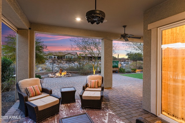 patio terrace at dusk with a ceiling fan and fence