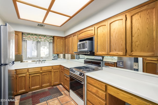 kitchen featuring light tile patterned flooring, a sink, visible vents, light countertops, and appliances with stainless steel finishes