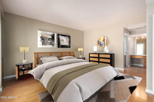 bedroom featuring light wood-type flooring, visible vents, and baseboards