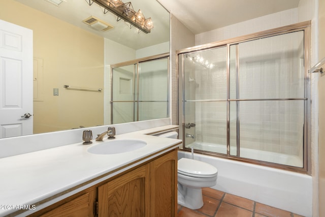 bathroom with toilet, vanity, visible vents, combined bath / shower with glass door, and tile patterned floors