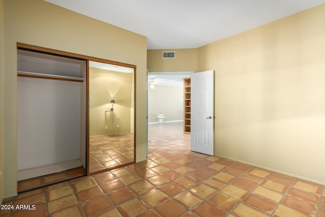 unfurnished bedroom with baseboards, visible vents, a closet, and tile patterned floors