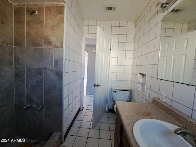 bathroom featuring a tile shower, tile patterned flooring, and tile walls