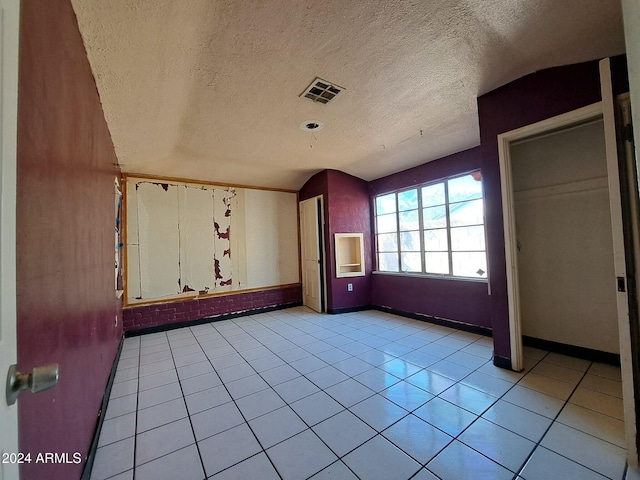 interior space with a textured ceiling and light tile patterned flooring