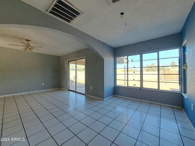 tiled spare room with ceiling fan and a textured ceiling