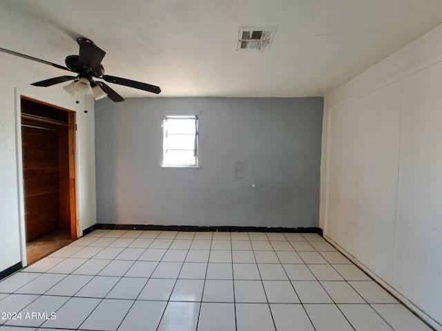 tiled empty room with ceiling fan