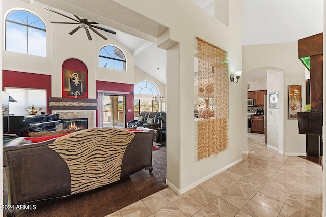 living room featuring ceiling fan, high vaulted ceiling, and light tile patterned floors