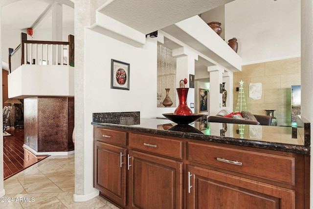 bar featuring dark stone countertops and light tile patterned floors