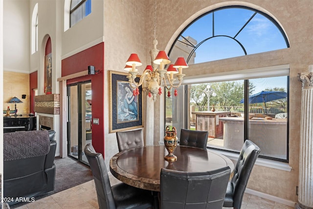 dining room with plenty of natural light, a towering ceiling, and a chandelier